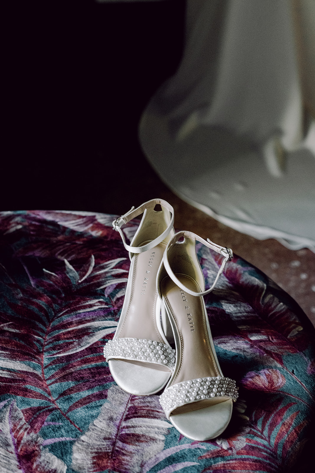 Kelly & Katie bridal heels on colorful ottoman at Mayfair House Hotel & Garden in Miami for wedding day details.