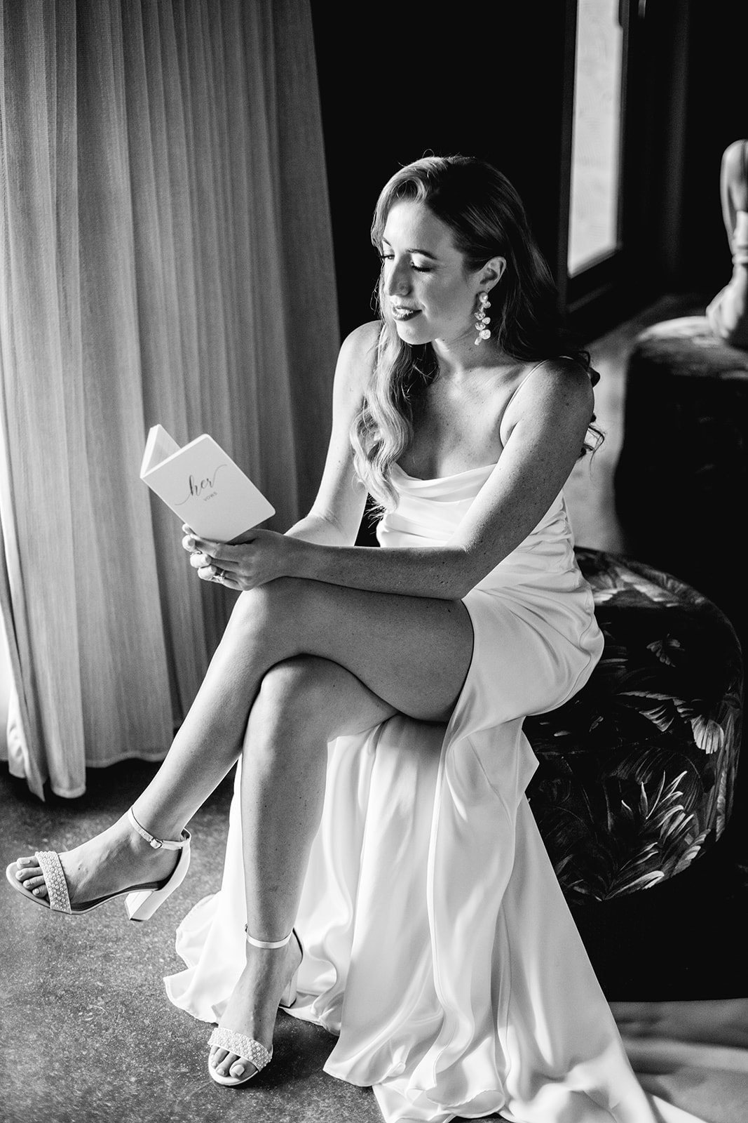 Bride reads her vow book before ceremony in room at Mayfair House Hotel & Garden in Miami on wedding day.