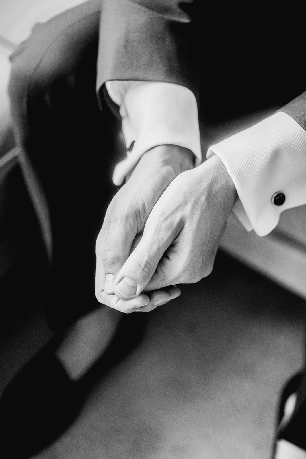 Black and white detail of groom's hands before ceremony at Mayfair House Hotel & Garden in Miami on wedding day.