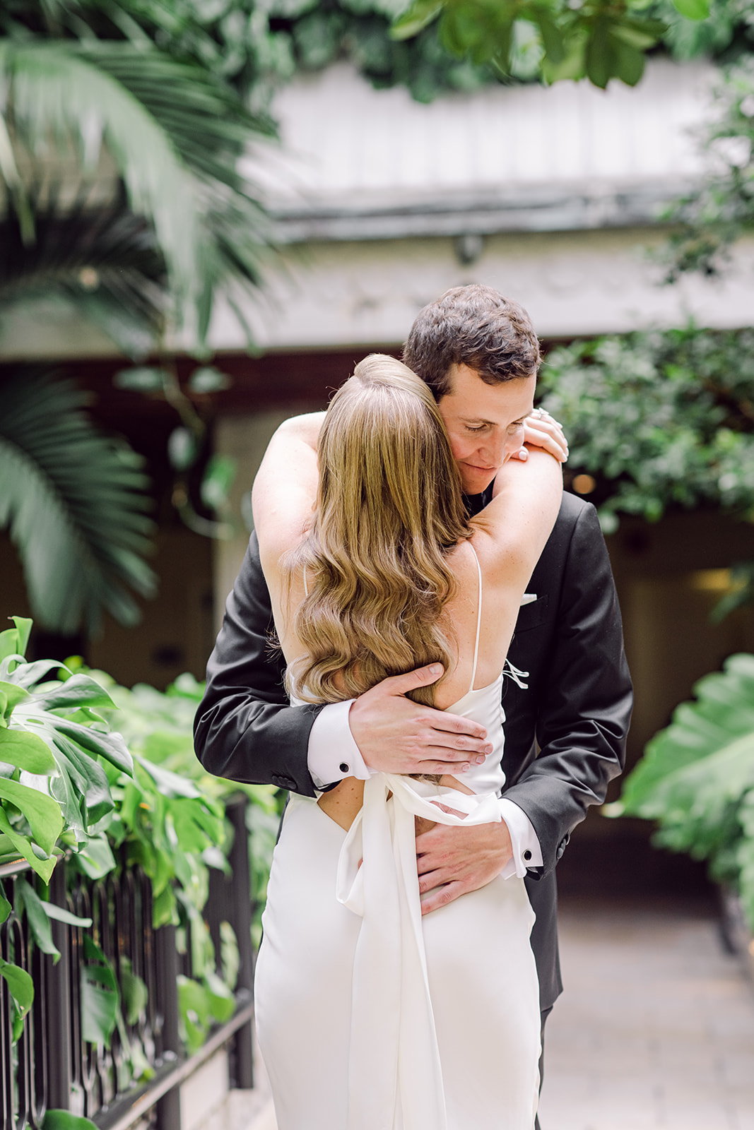 Bride & groom embrace during first look at Mayfair House Hotel & Garden in Miami on wedding day.