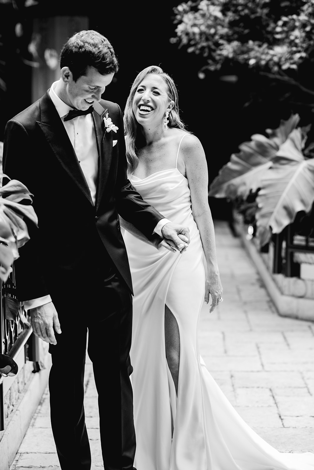 Black and white of bride & groom laughing after first look at Mayfair House Hotel & Garden in Miami on wedding day.