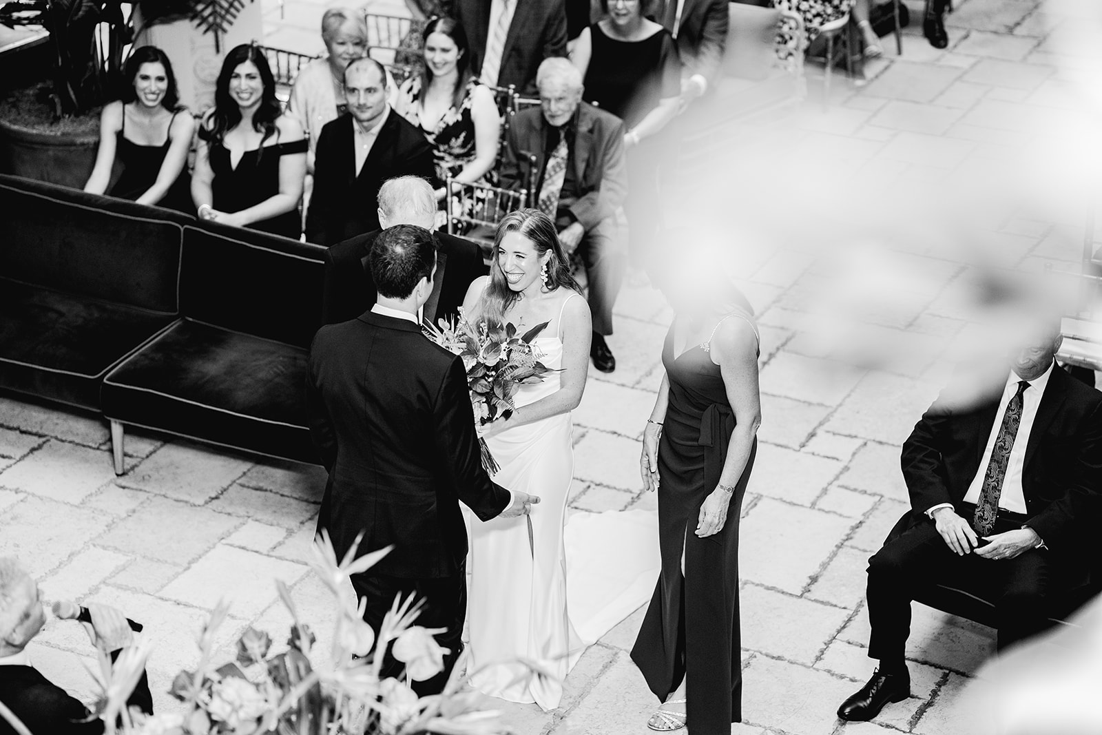 Black and white bride meets groom at altar during ceremony at Mayfair House Hotel & Garden in Miami on wedding day.