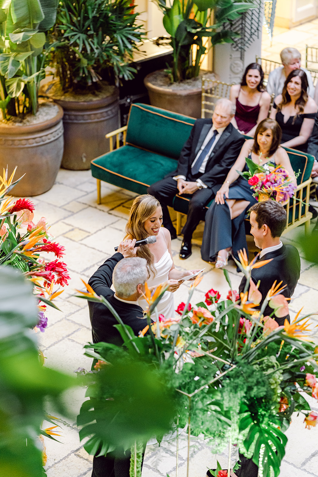 Looking down on bride reading vows to groom during ceremony at Mayfair House Hotel & Garden in Miami on wedding day.