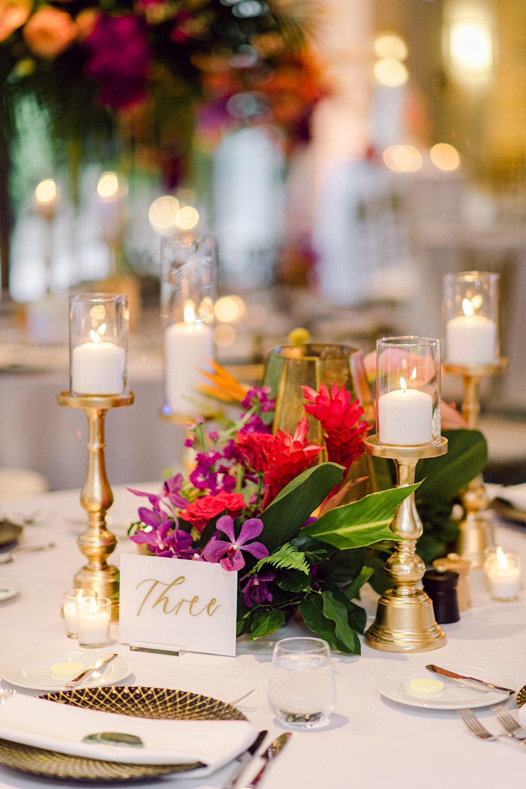 Table decor detail of candles and flowers for reception at Mayfair House Hotel & Garden in Miami on wedding day.