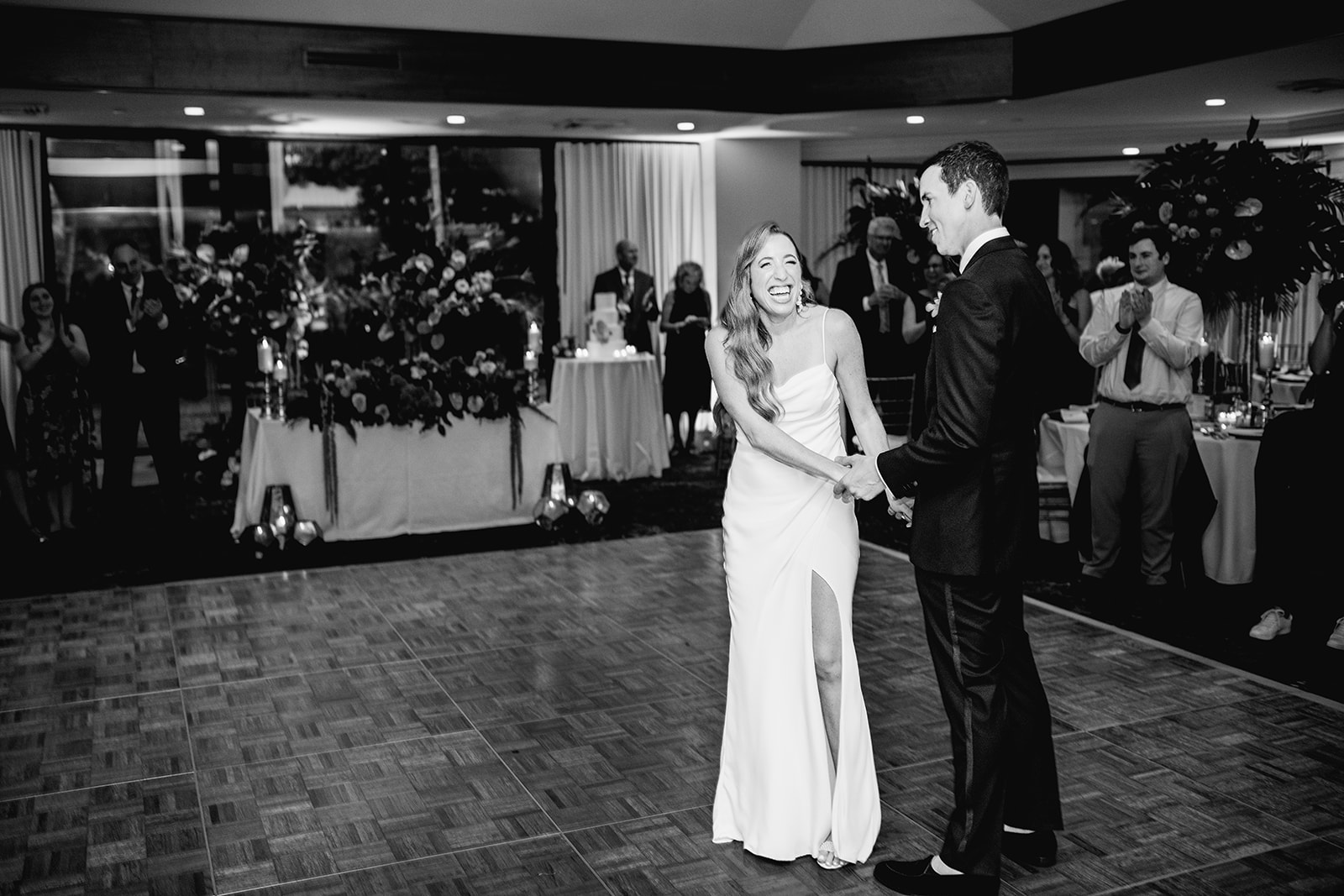 Black and white bride and groom laugh first dance at reception at Mayfair House Hotel & Garden, Miami on wedding day.