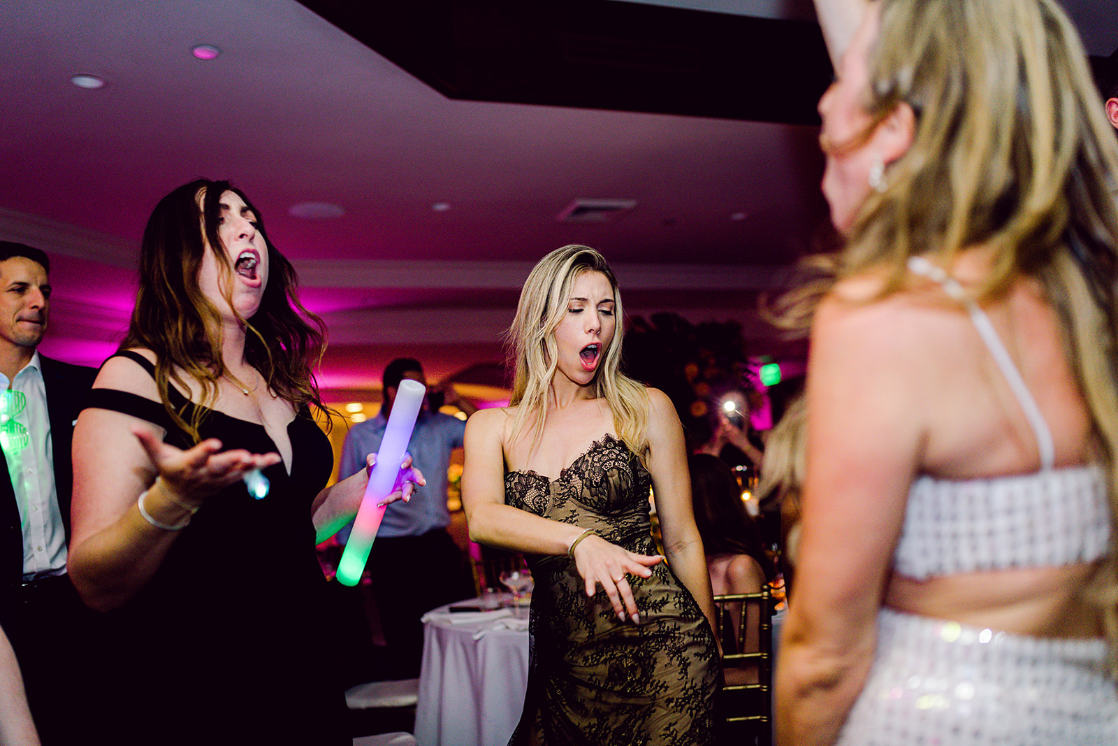 Bride dances with girlfriends on dance floor at wedding reception of Mayfair House Hotel & Garden, Miami.