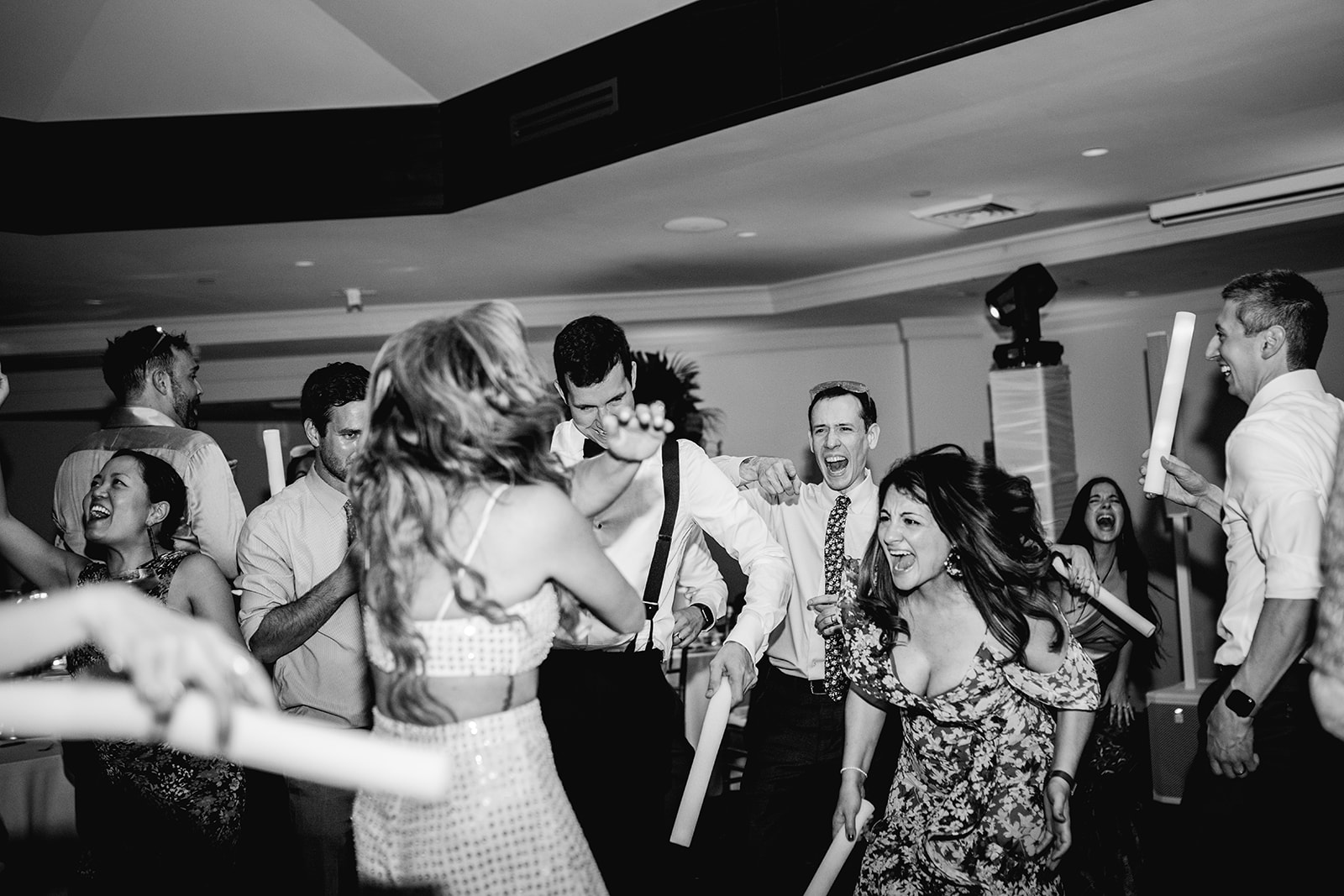 Black and white of bride and groom dancing with wild crowd at wedding reception of Mayfair House Hotel & Garden, Miami.