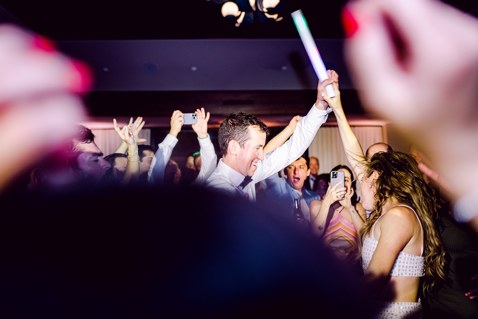 Wild crowd and bride and groom rave dance together at wedding reception of Mayfair House Hotel & Garden, Miami.