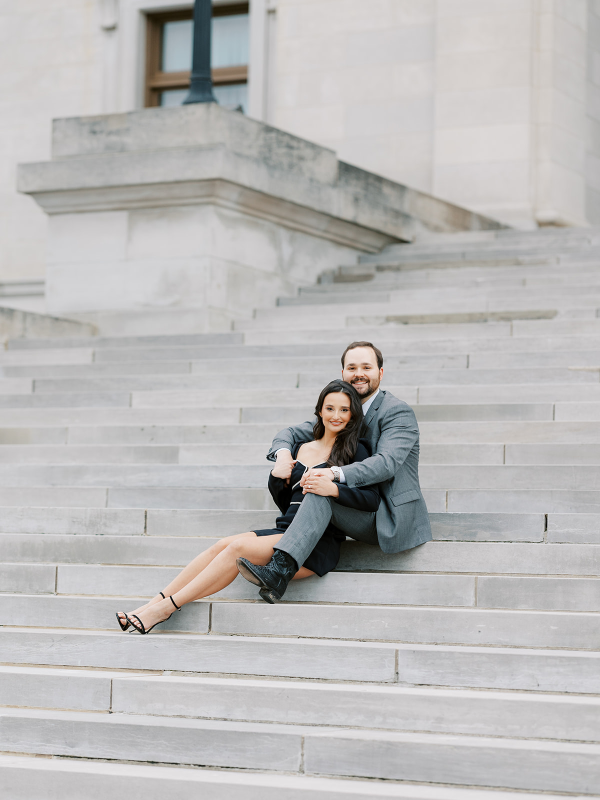 Couple sits together on the steps of the Arkansas State Capitol in Little Rock