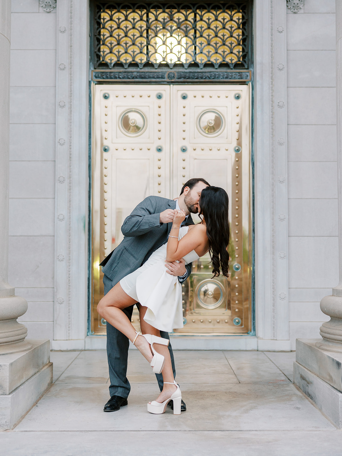 Couple dips in front of gold doors at the Arkansas State Capitol