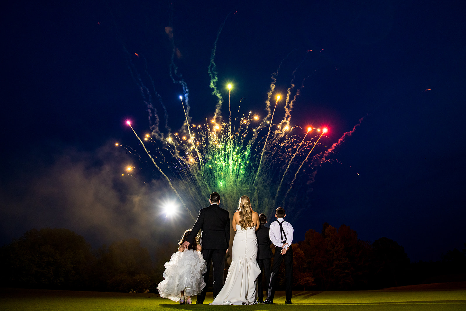 Wedding couple watches fireworks on the putting green during their country club wedding reception