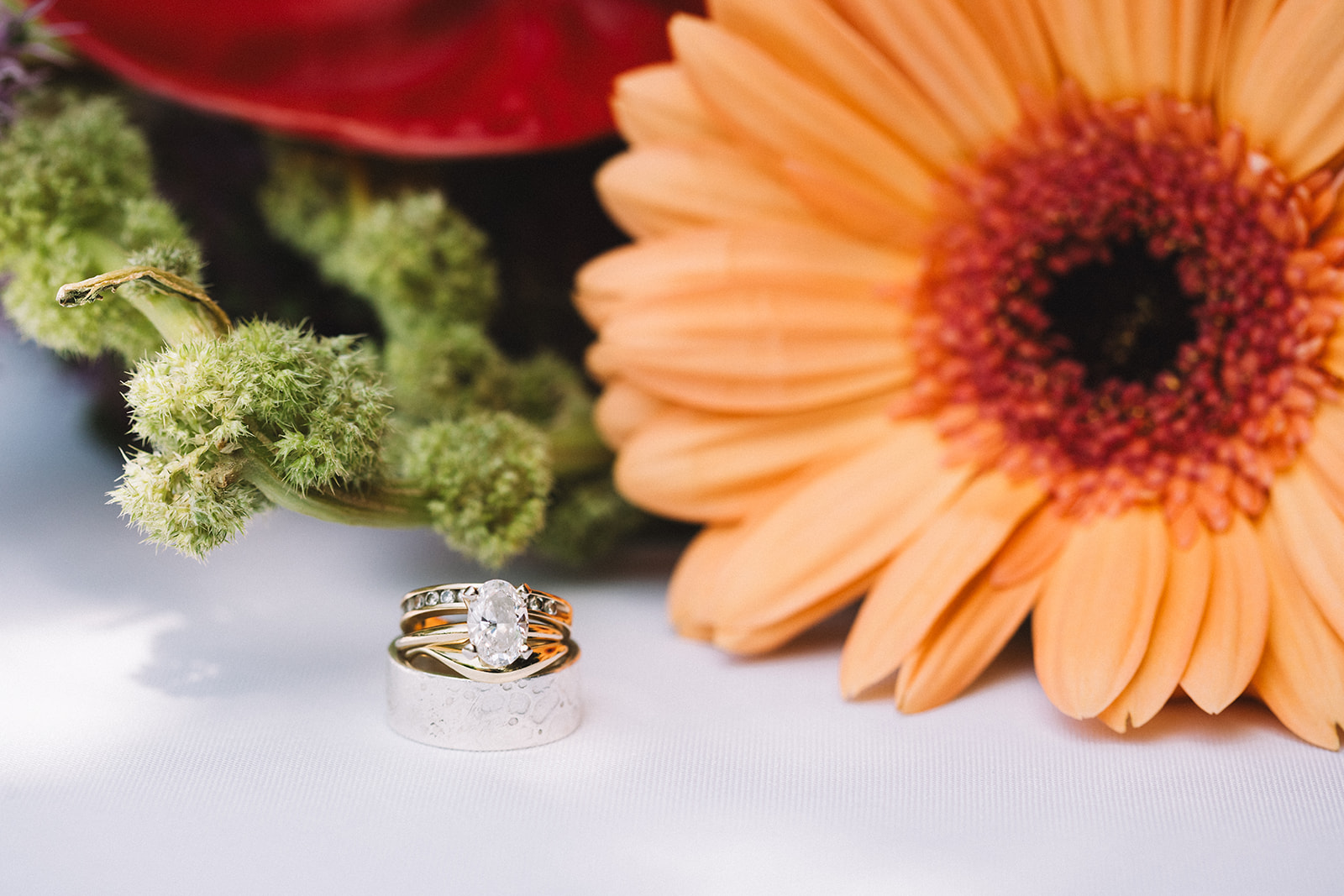 Colorful orange and red wedding florals and beautiful wedding bands. 