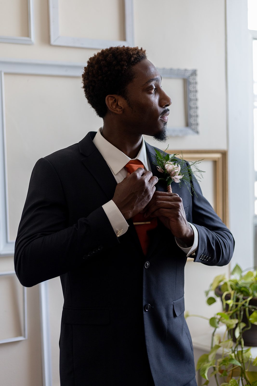 Groom adjusts suit and boutonniere