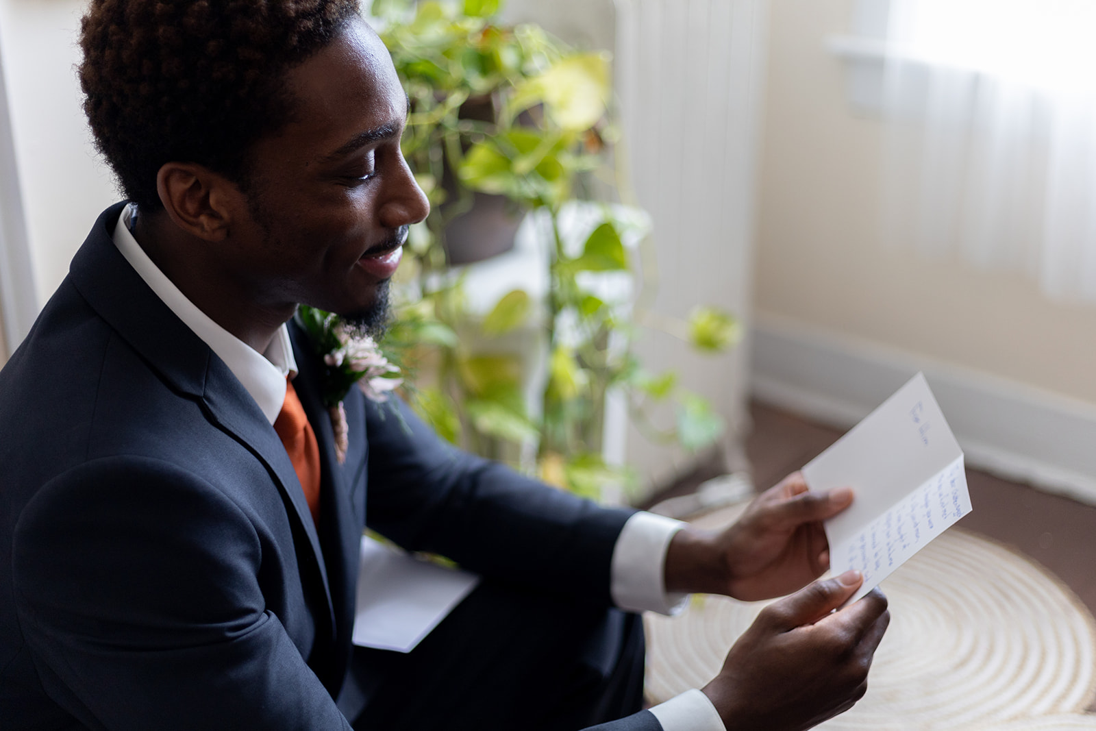 Groom reads letter from bride while getting ready