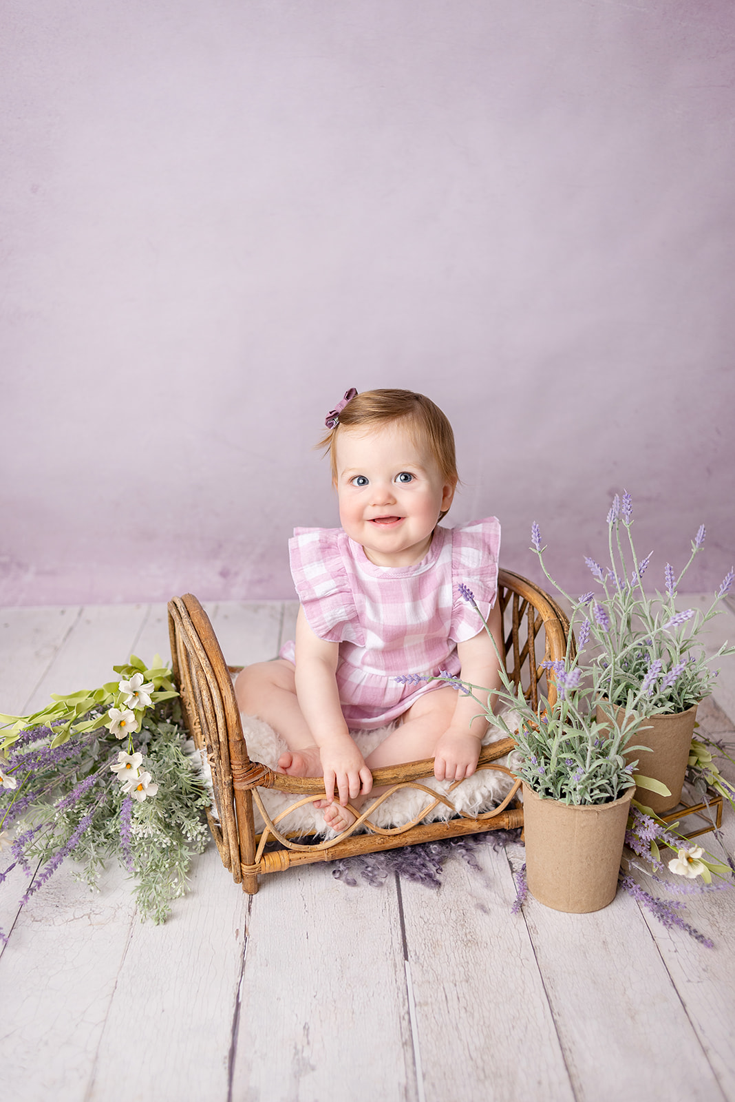 Smiling one year old girl in all purple at a photography studio located in Carthage, Missouri
