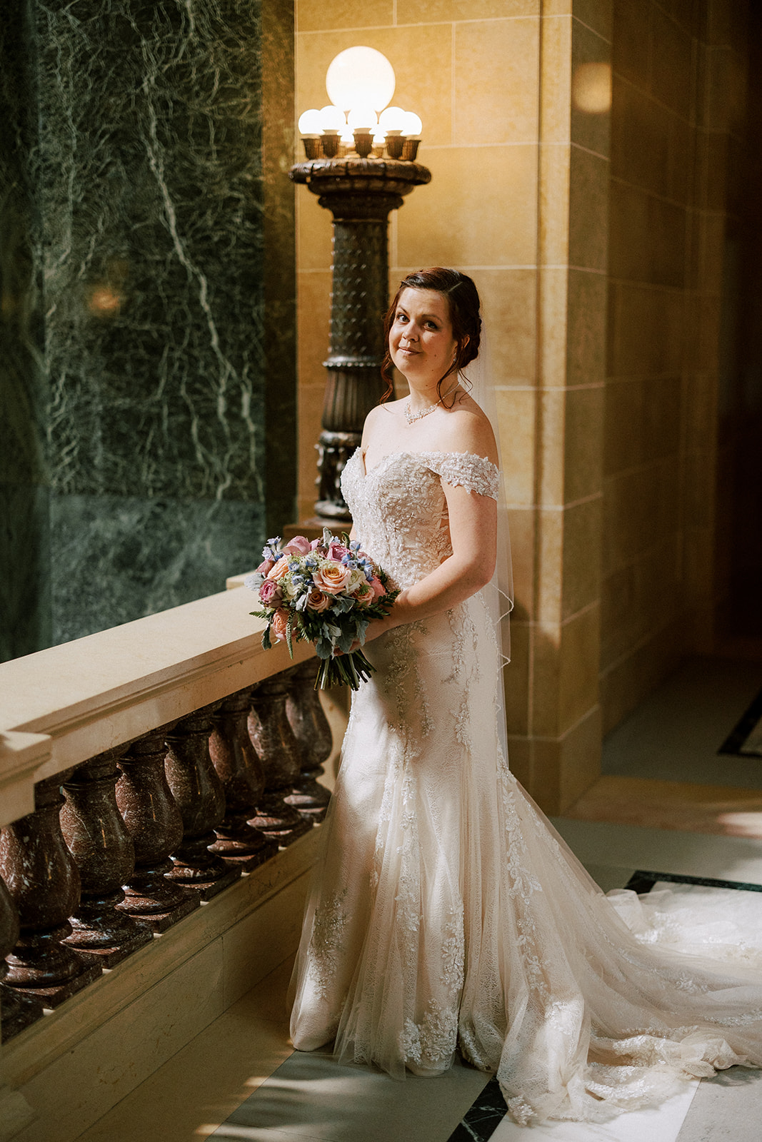 bride poses inside wisconsin capitol building on her wedding day