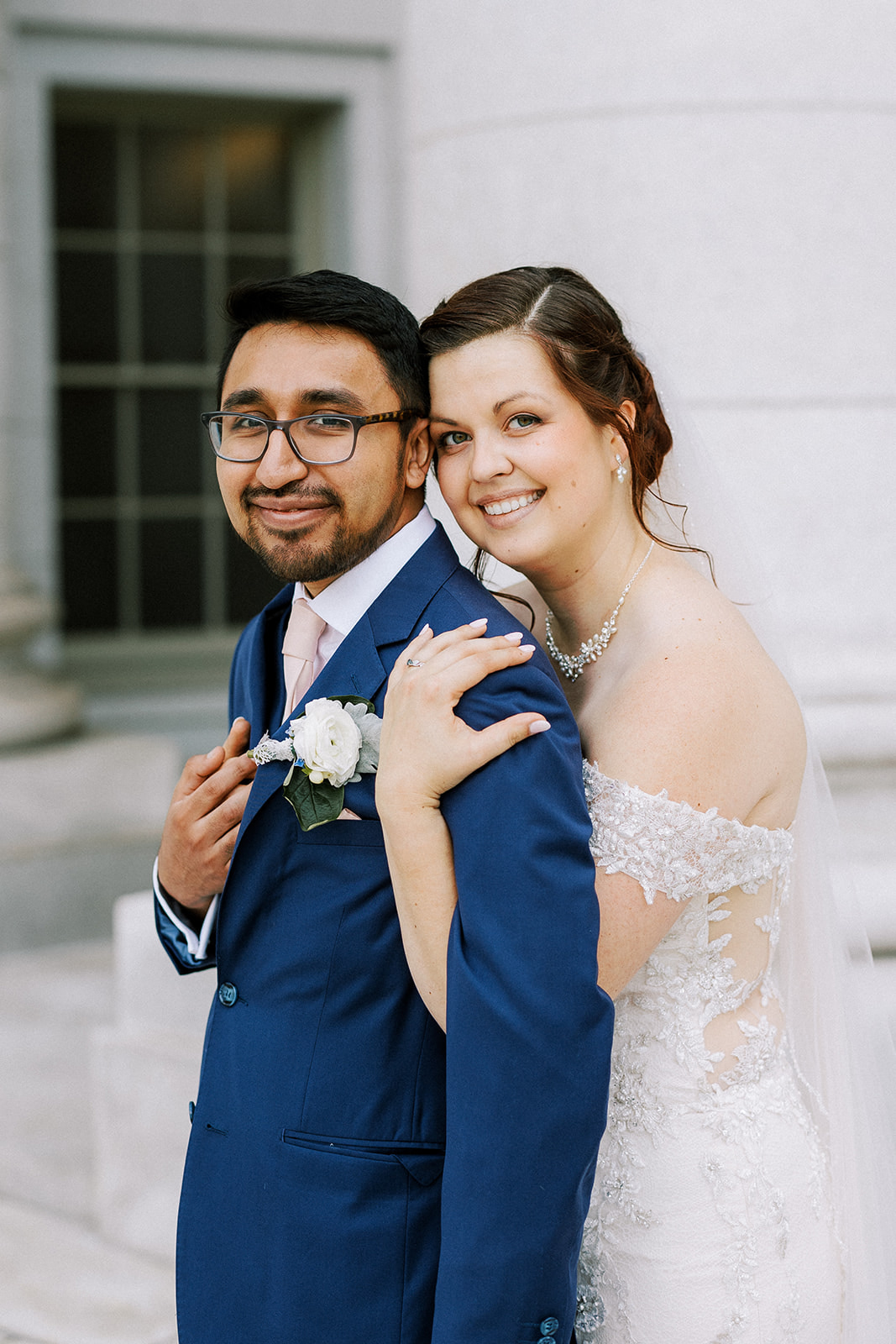 a newly married couple embraces outside of the capitol building in madison wisconsin on their wedding day