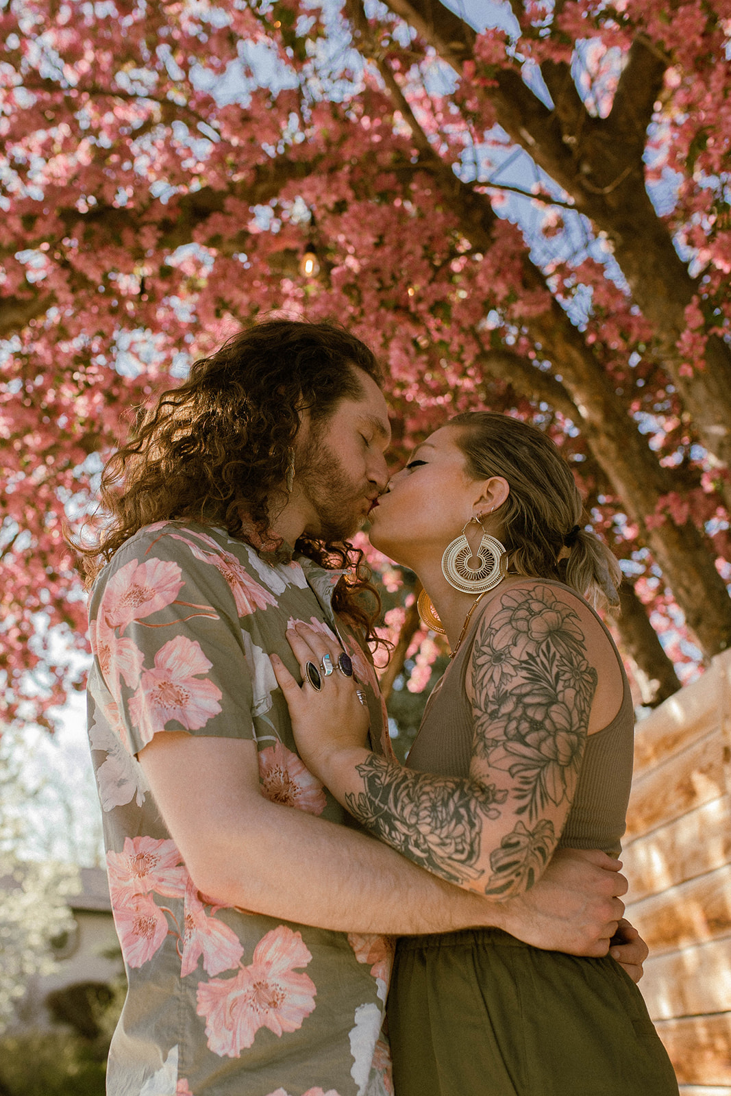 couple kissing under a blossoming tree