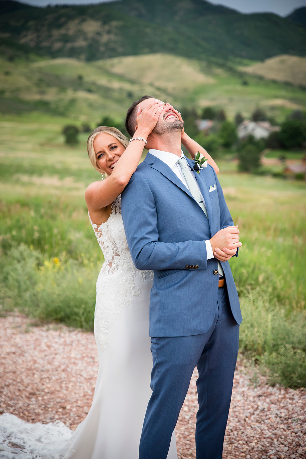 Bride comes up behind groom and puts her hands over his eyes.