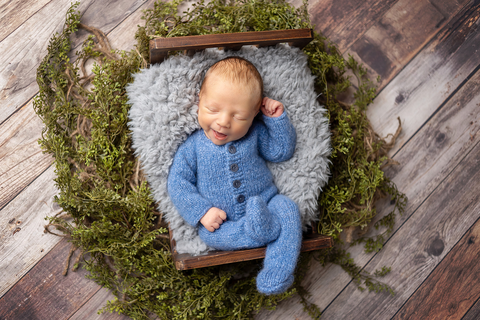 Newborn boy at Celesta Champagne Photography studio sleeping in a blue knit outfit