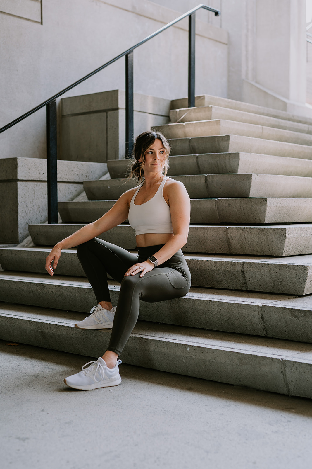 athletic woman sitting on concrete staircase