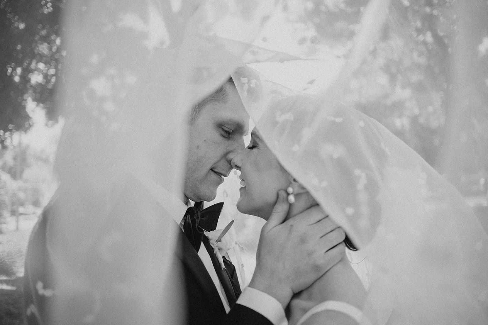 couple embrace under the bride's veil on their wedding day in madison wisconsin