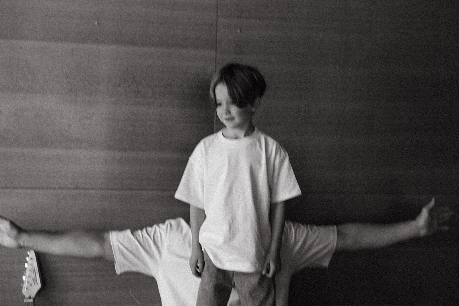 black and white photo of son standing with dads arms outstretched