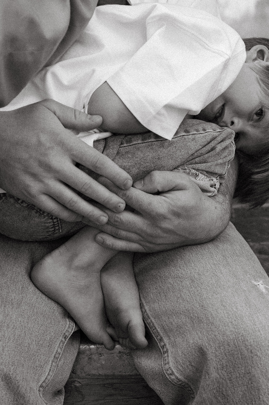 detail photo of dad holding son in black and white