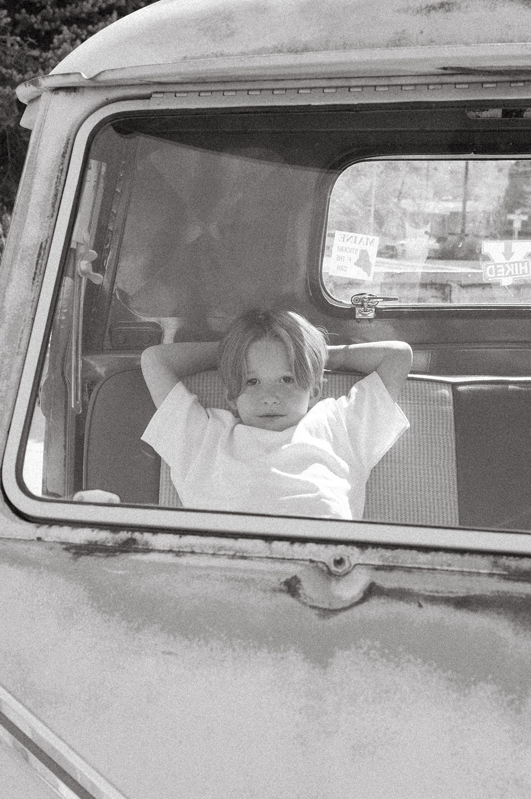 little boy sits in front seat of VW truck in black and white portrait