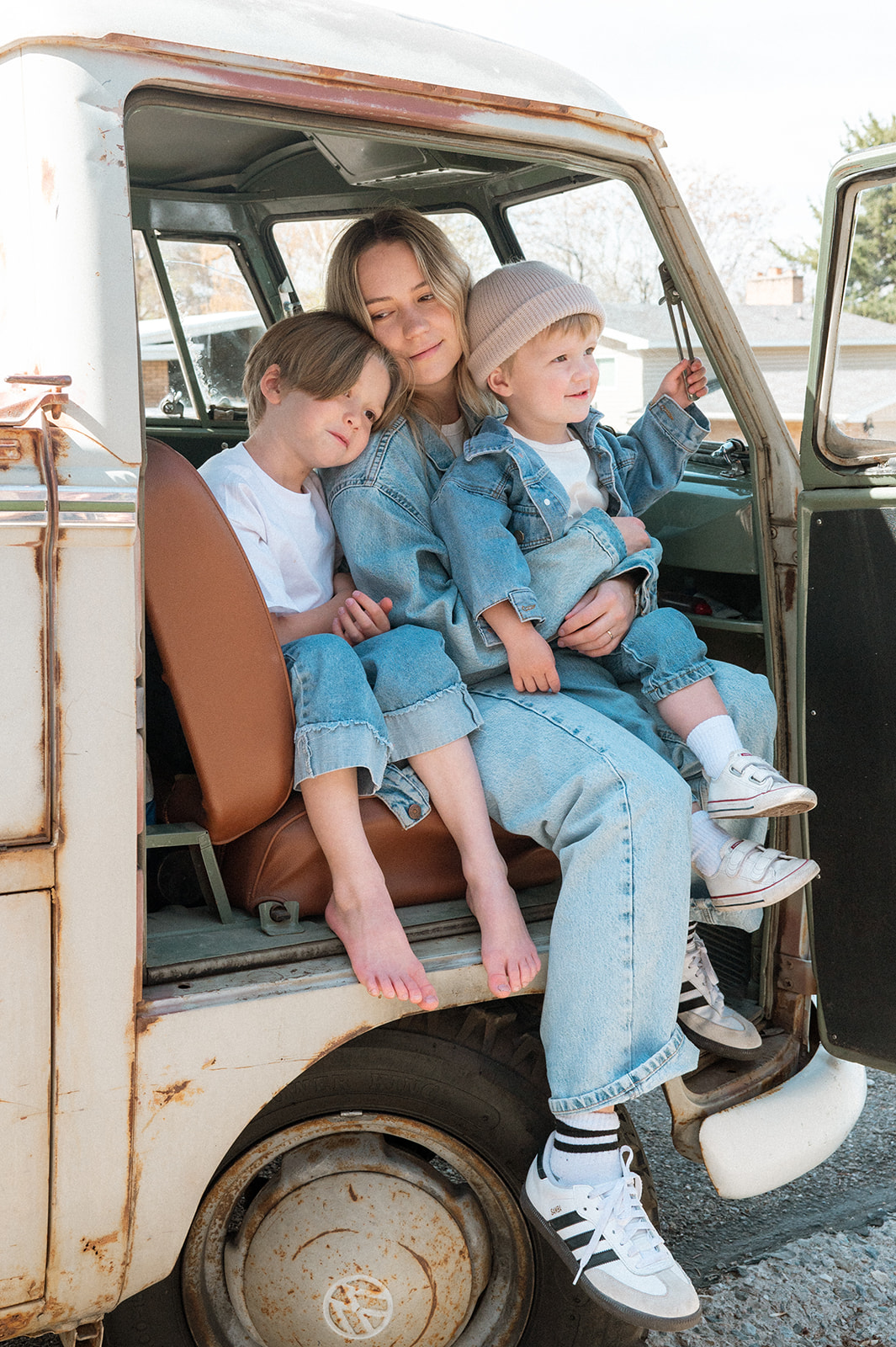 mother and sons sit together in front seat of VW truck in portrait session in Provo Utah