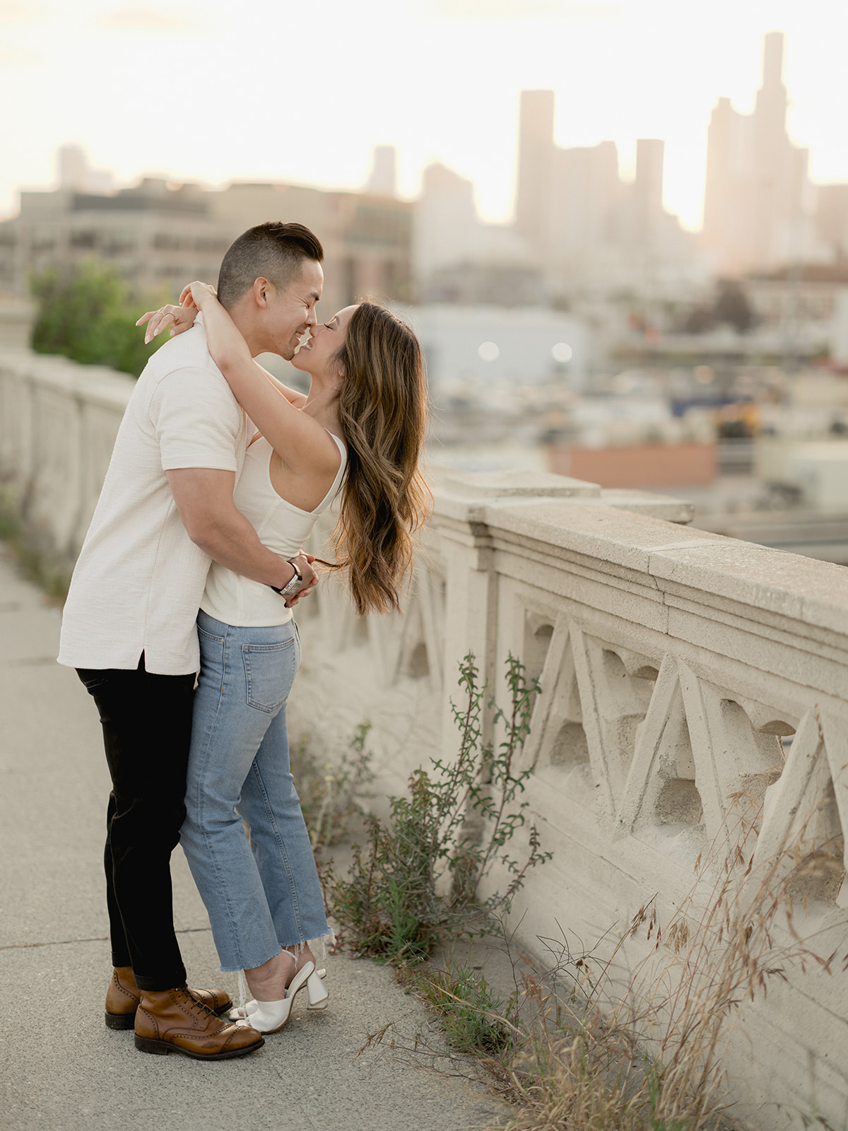Engaged couple kisses on the 4th street bridge downtown during sunset