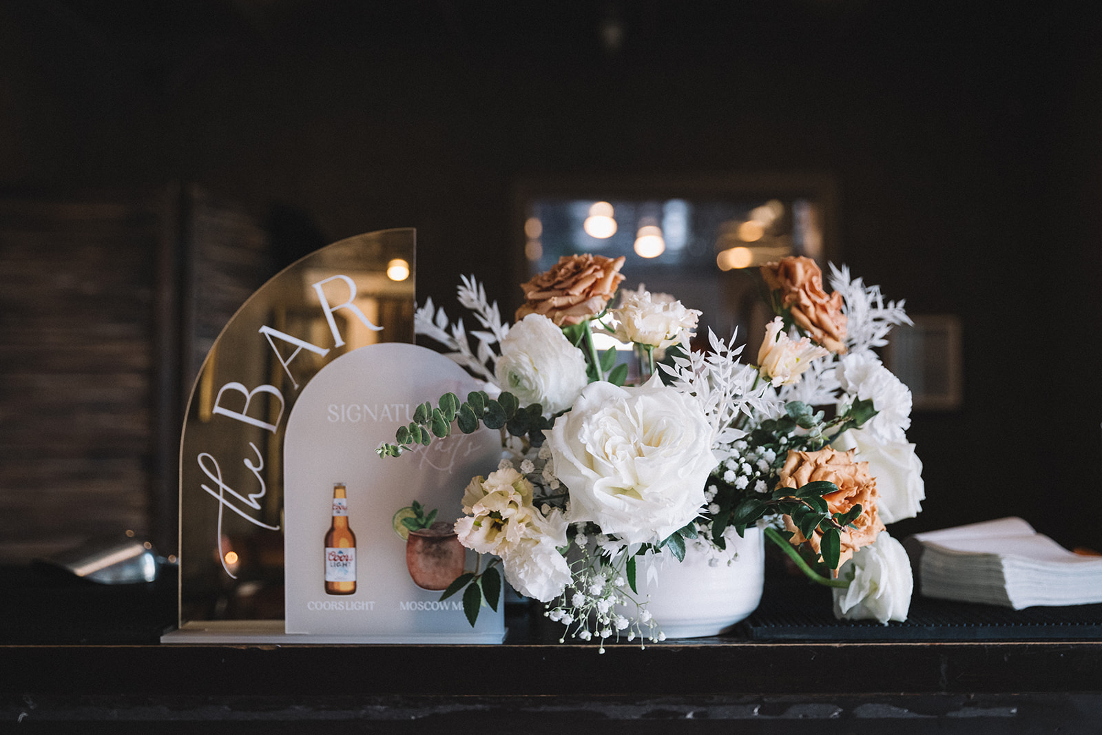 Neutral wedding florals and signature cocktail hour bar signs. 