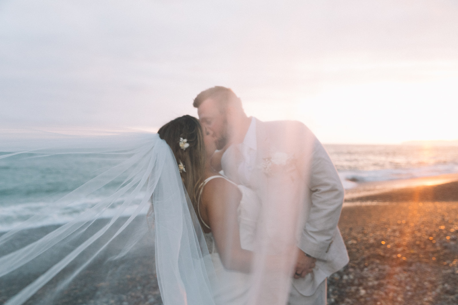 Veil photos during sunset golden hour portrait session for the bride and groom on the beach in San Clemente venue. 