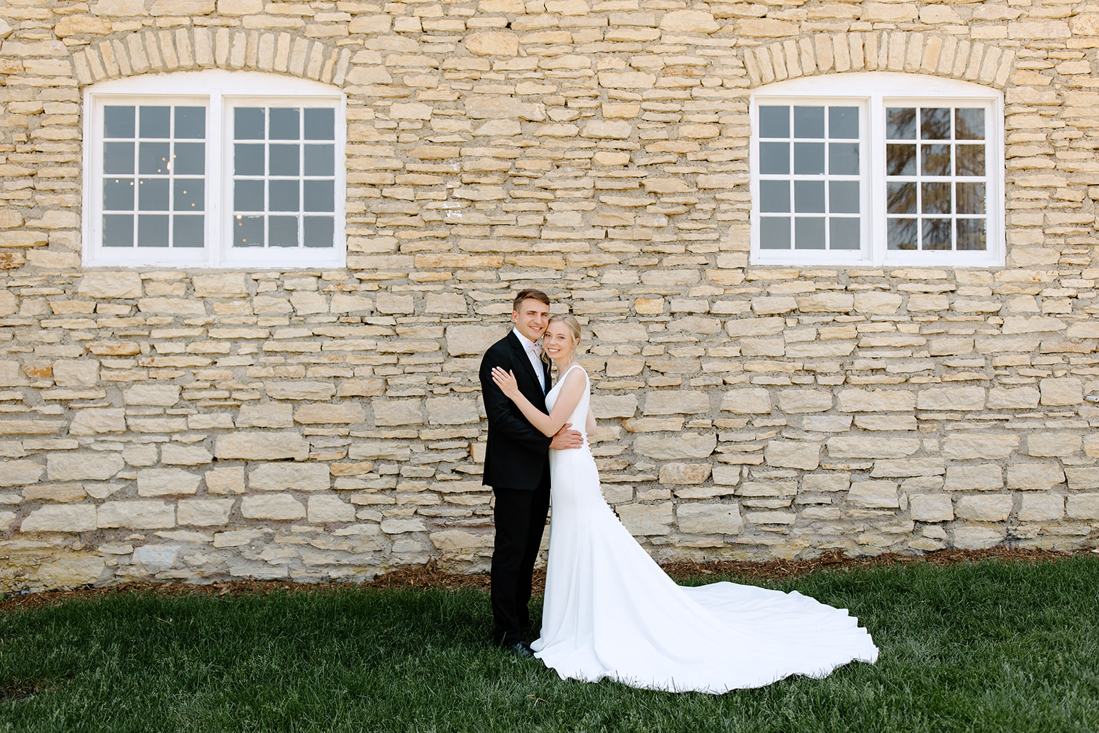 Bride and groom in front of a brick wall