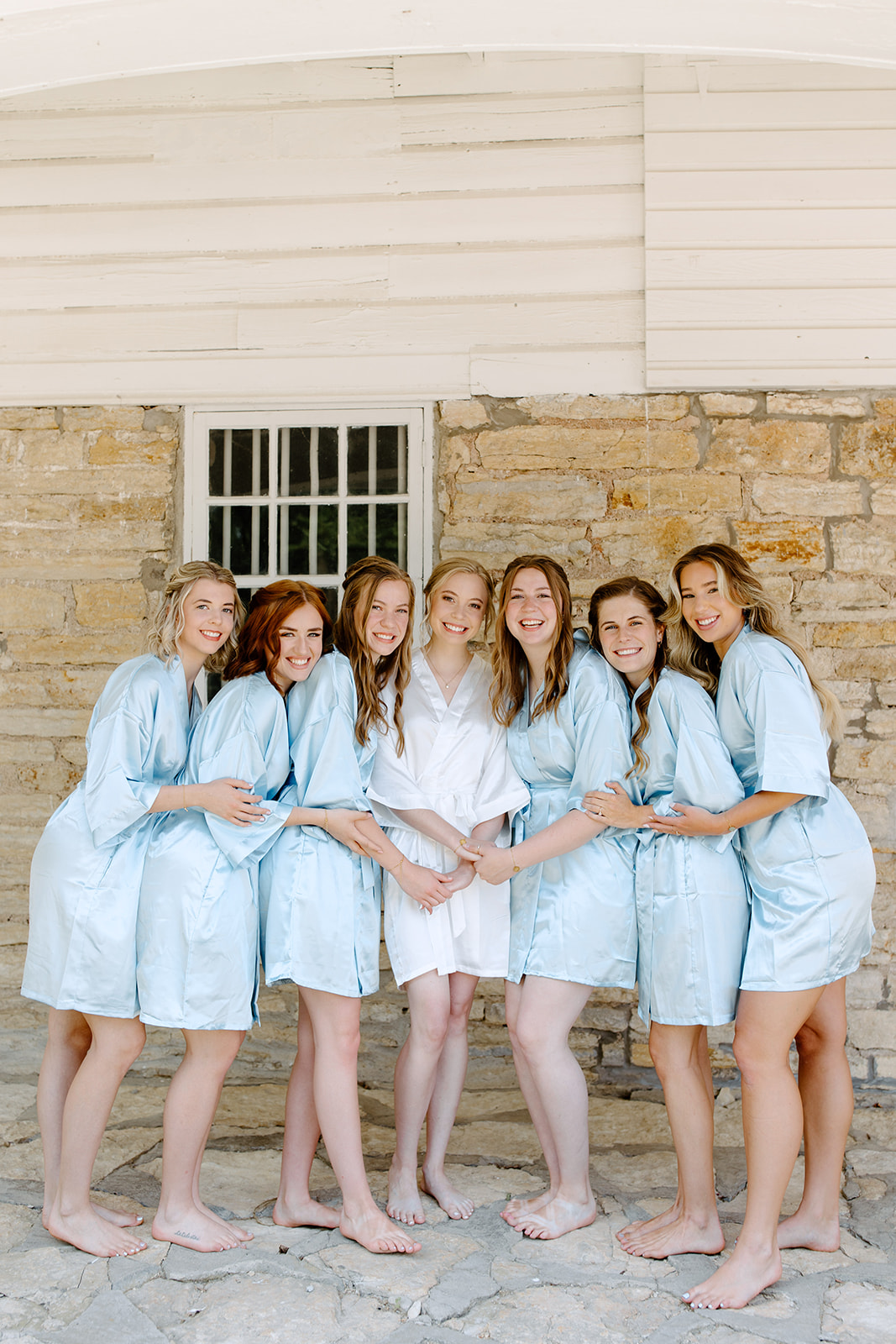 Bride and her bridesmaids pose in matching robes