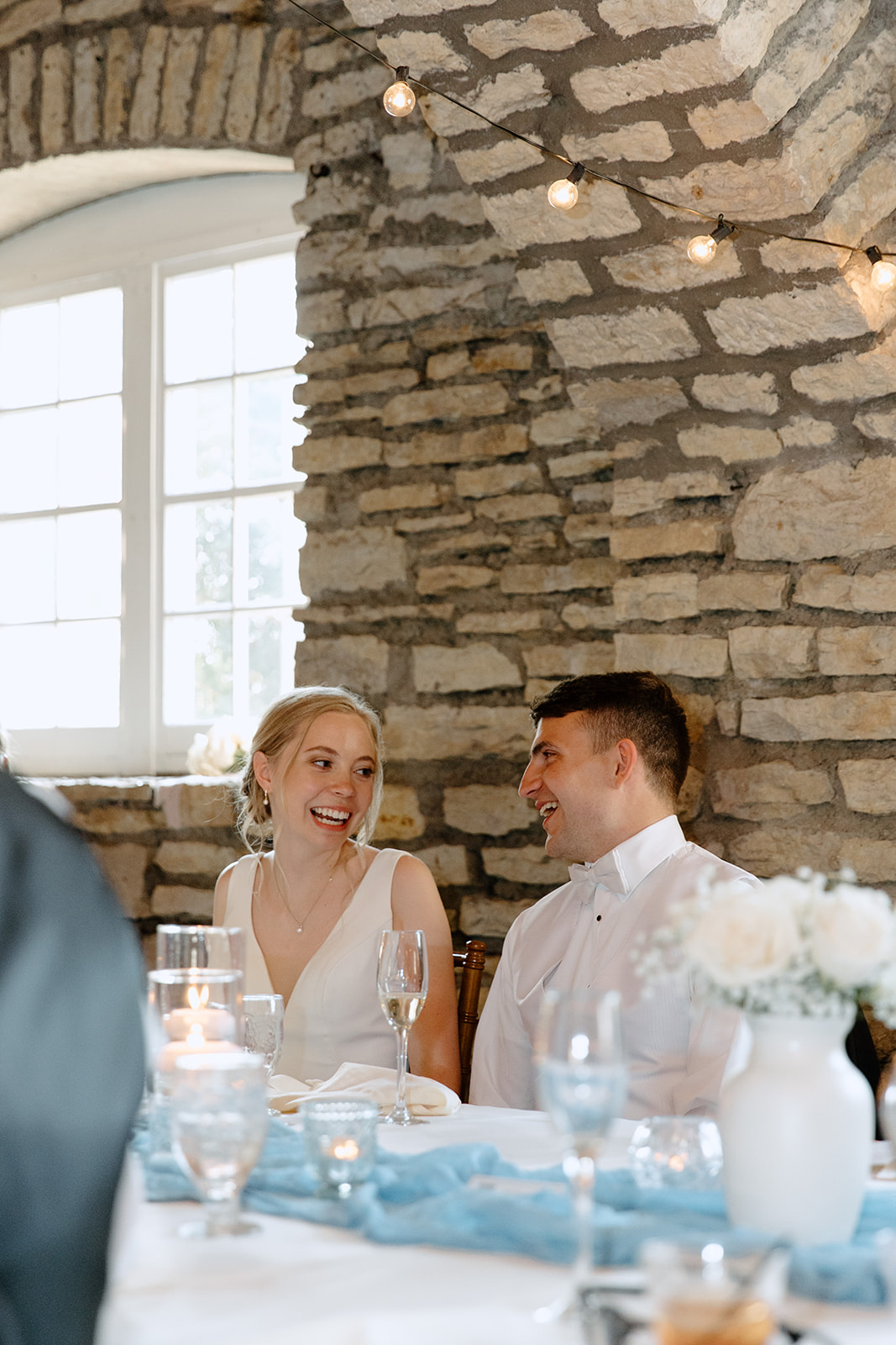 Bride and groom laughing during dinner