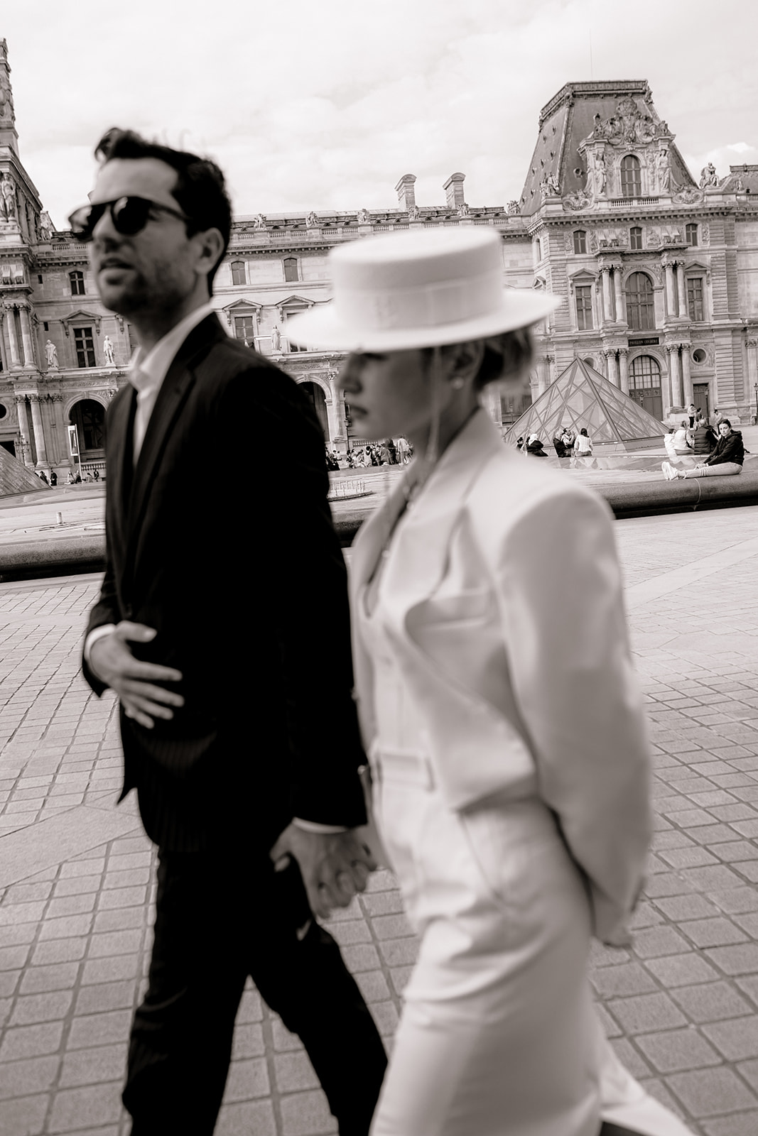 Sophisticated elegant french couple walking at the louvre in Paris, black and white blurry motion image