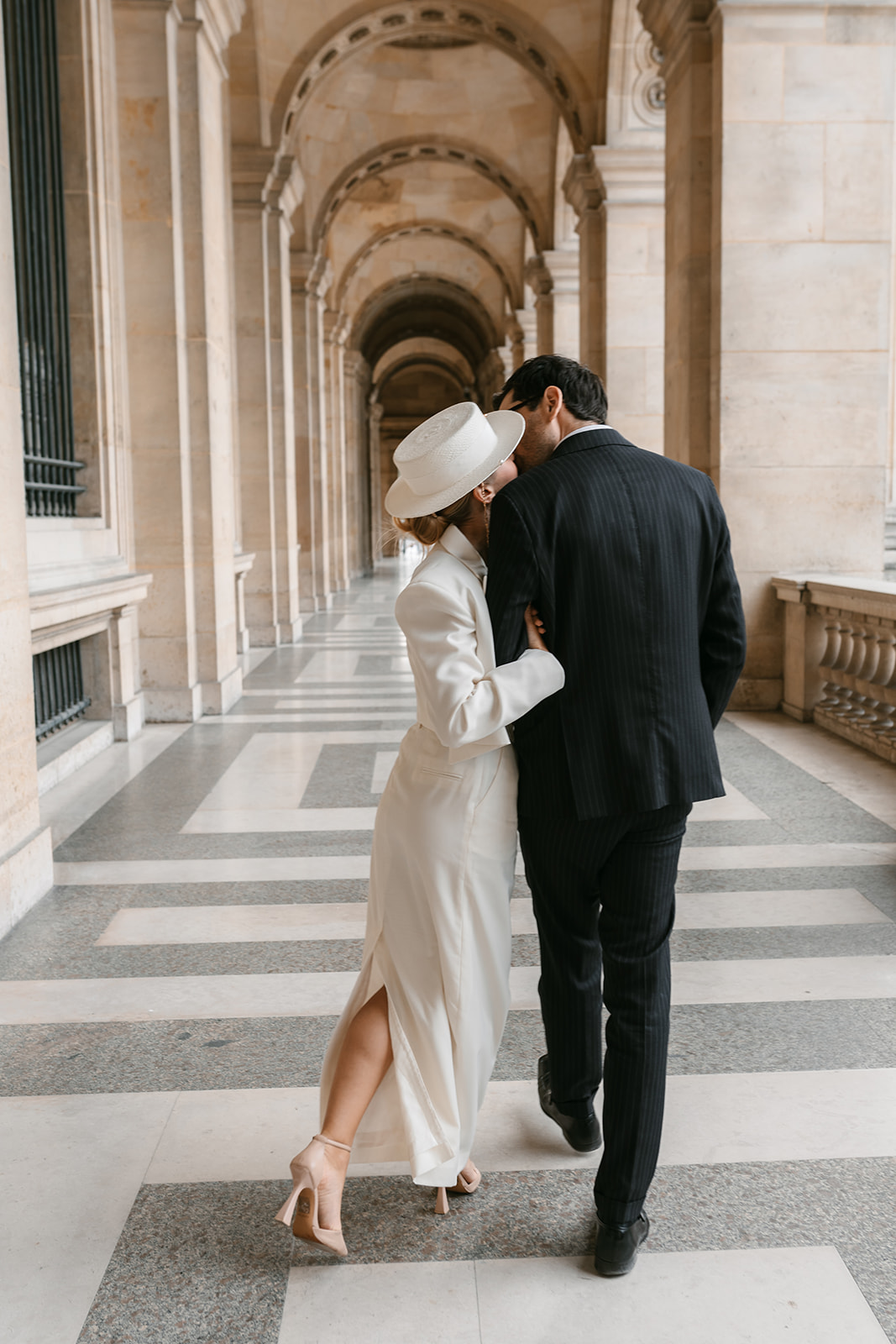 Sophisticated elegant french couple kissing at the louvre in Paris