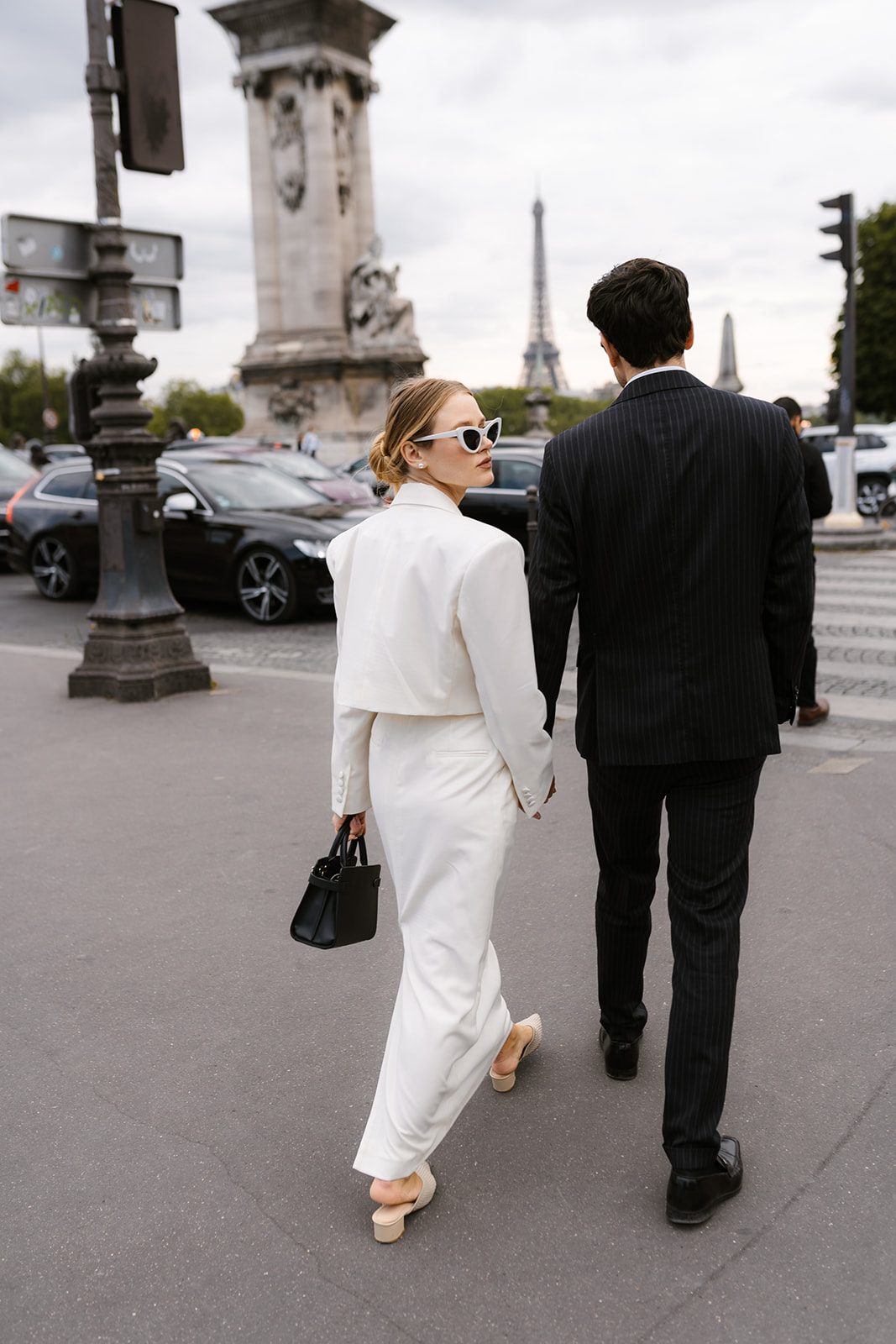 Sophisticated elegant french couple walking in Paris with the Tour Eiffel in the background