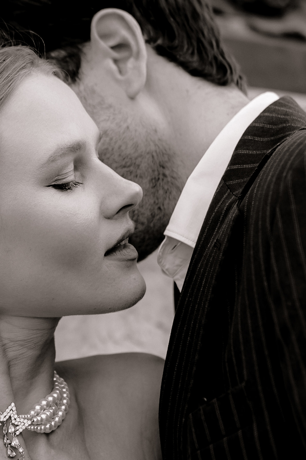 Sophisticated elegant french couple whispering secrets in black and white