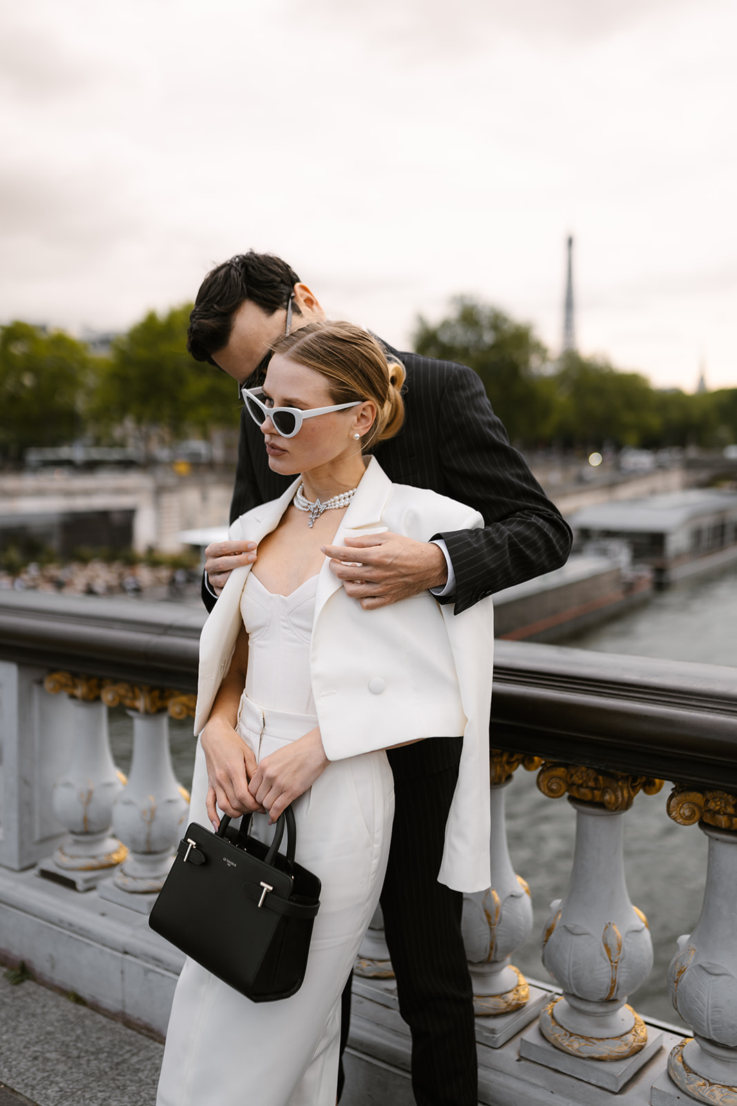 Sophisticated elegant french couple in front of the Tour Eiffel on pont alexandre III
