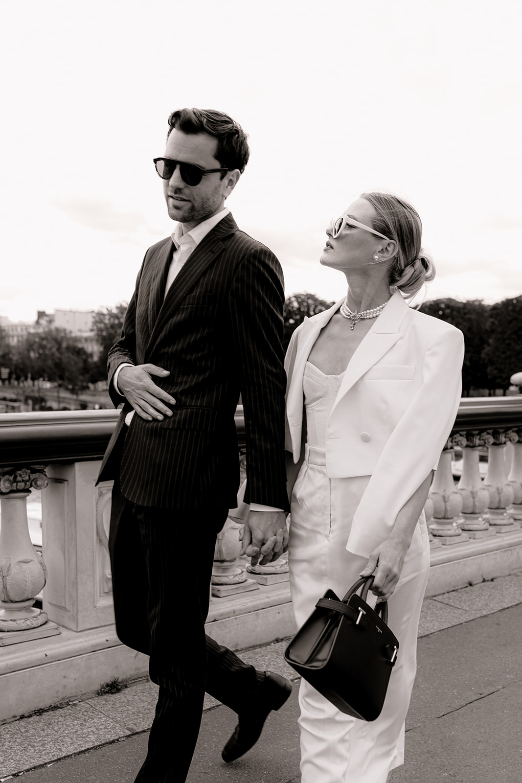 Sophisticated elegant french couple walking in front of the Tour Eiffel on pont alexandre III