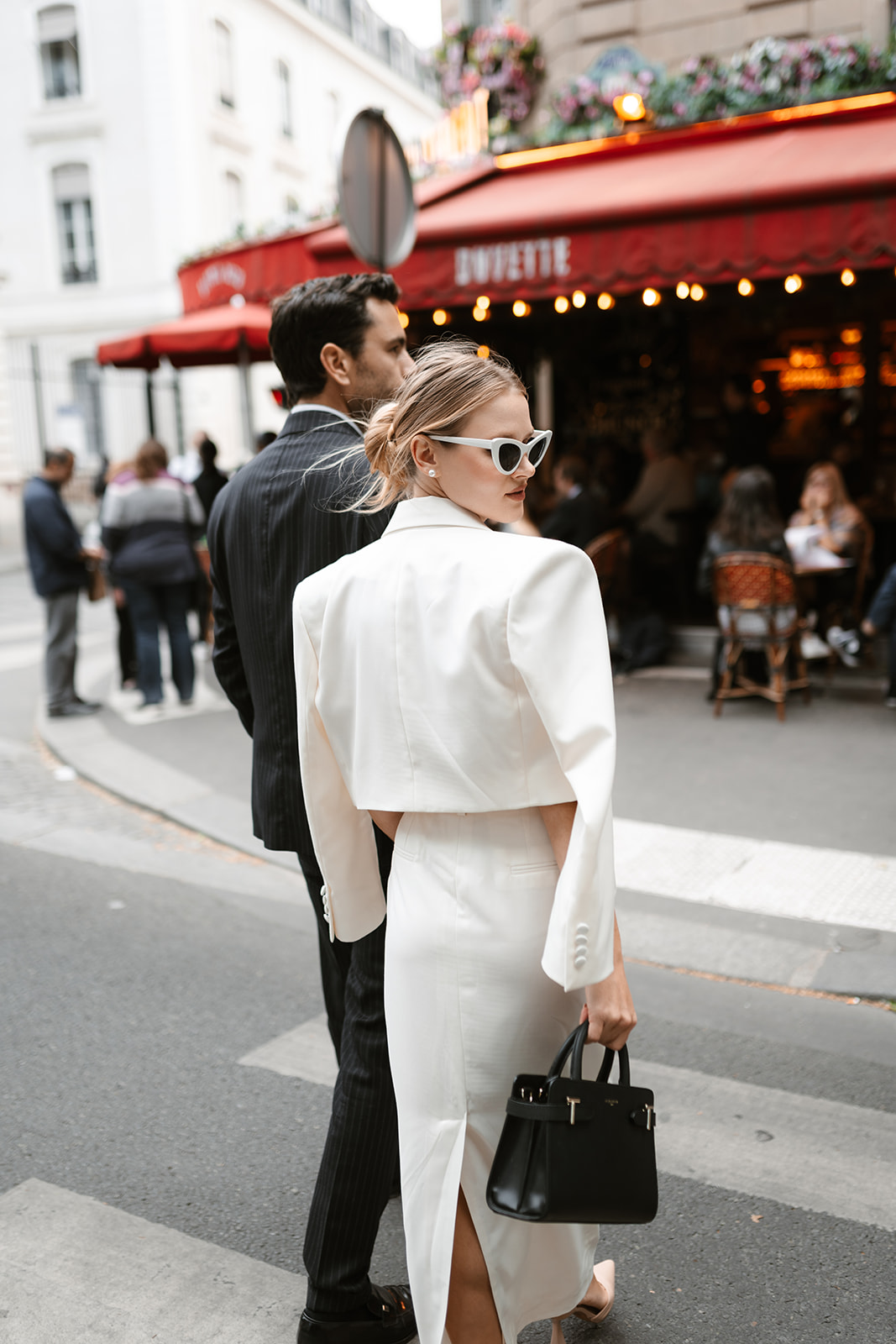 Sophisticated elegant french couple walking towards a french bistrot