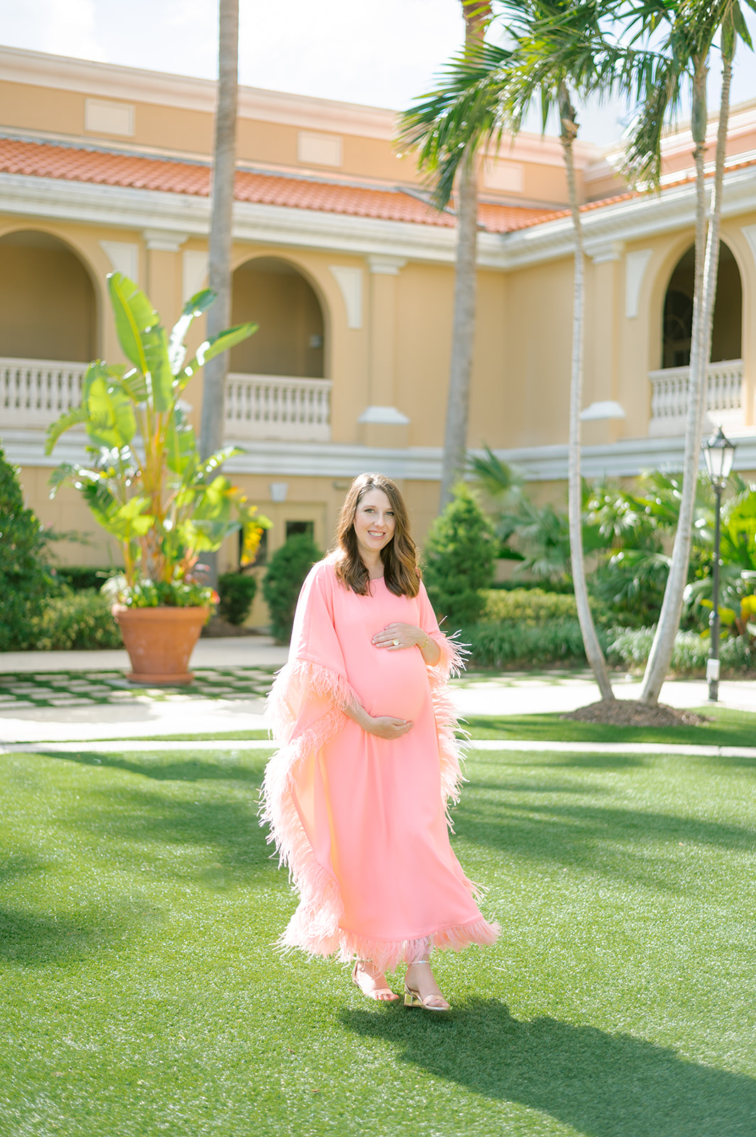 Amanda beaming in her custom green maternity dress at The Ritz Carlton