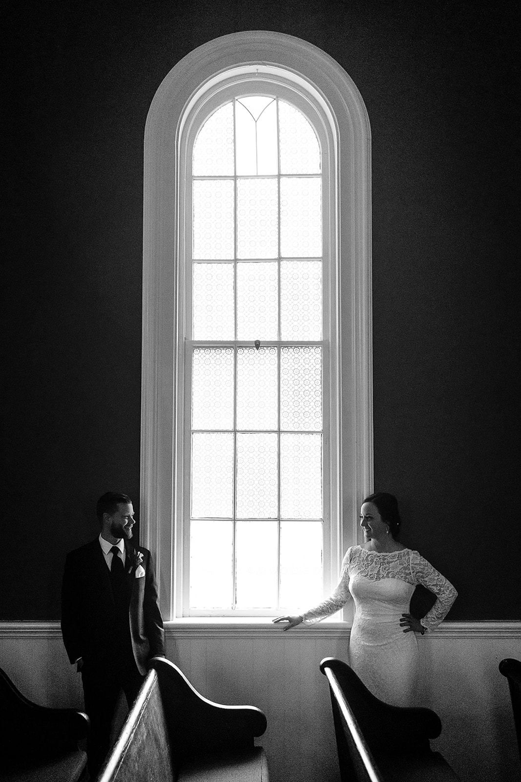 bride and groom portrait in front of large window at st. johns church in port gamble