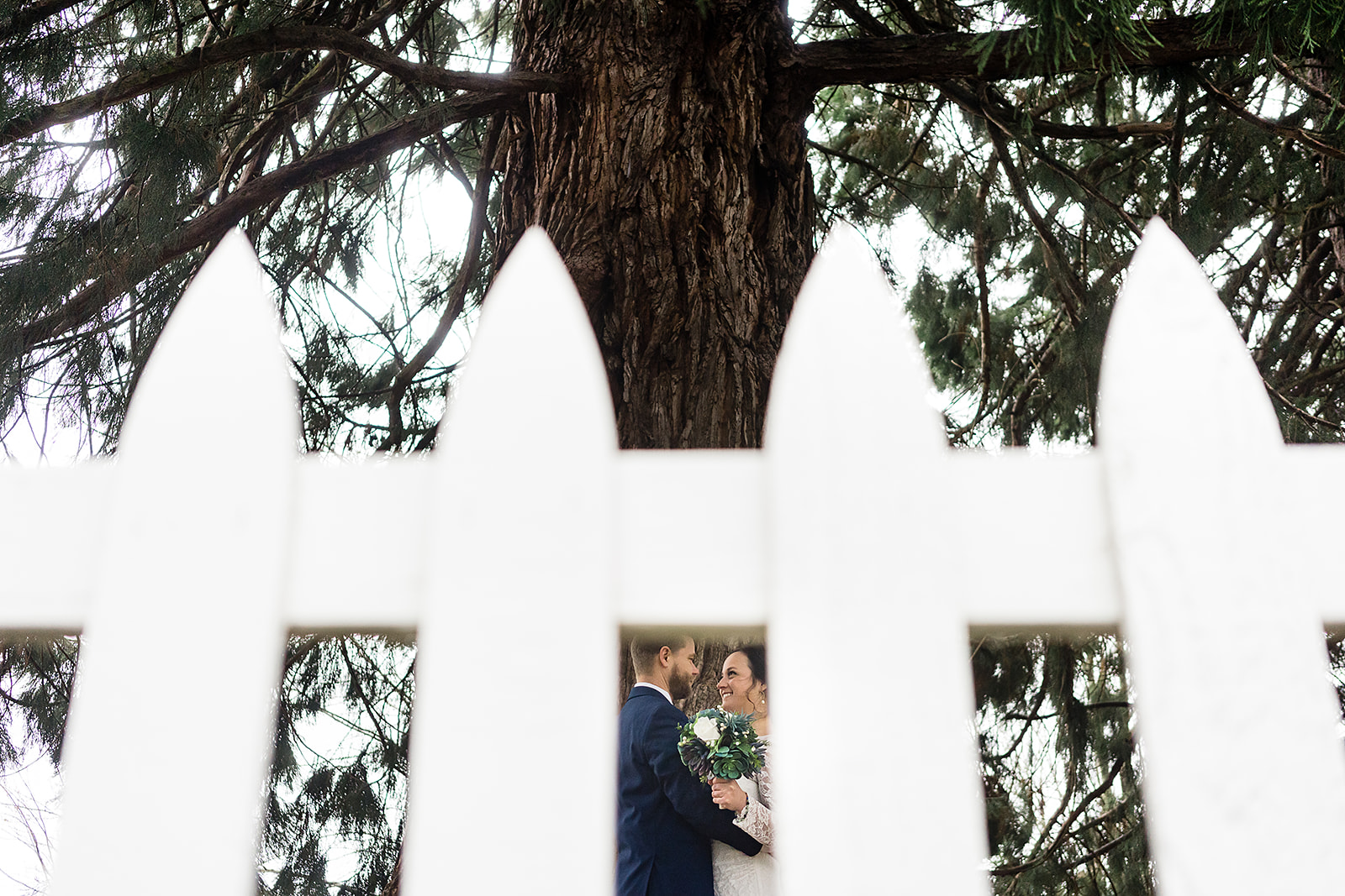 bride and groom portraits photographed through fence at port gamble wedding