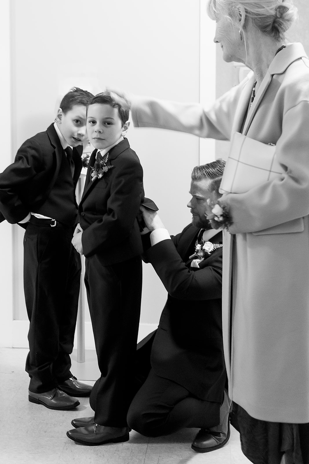 groom helps sons get ready for wedding ceremony