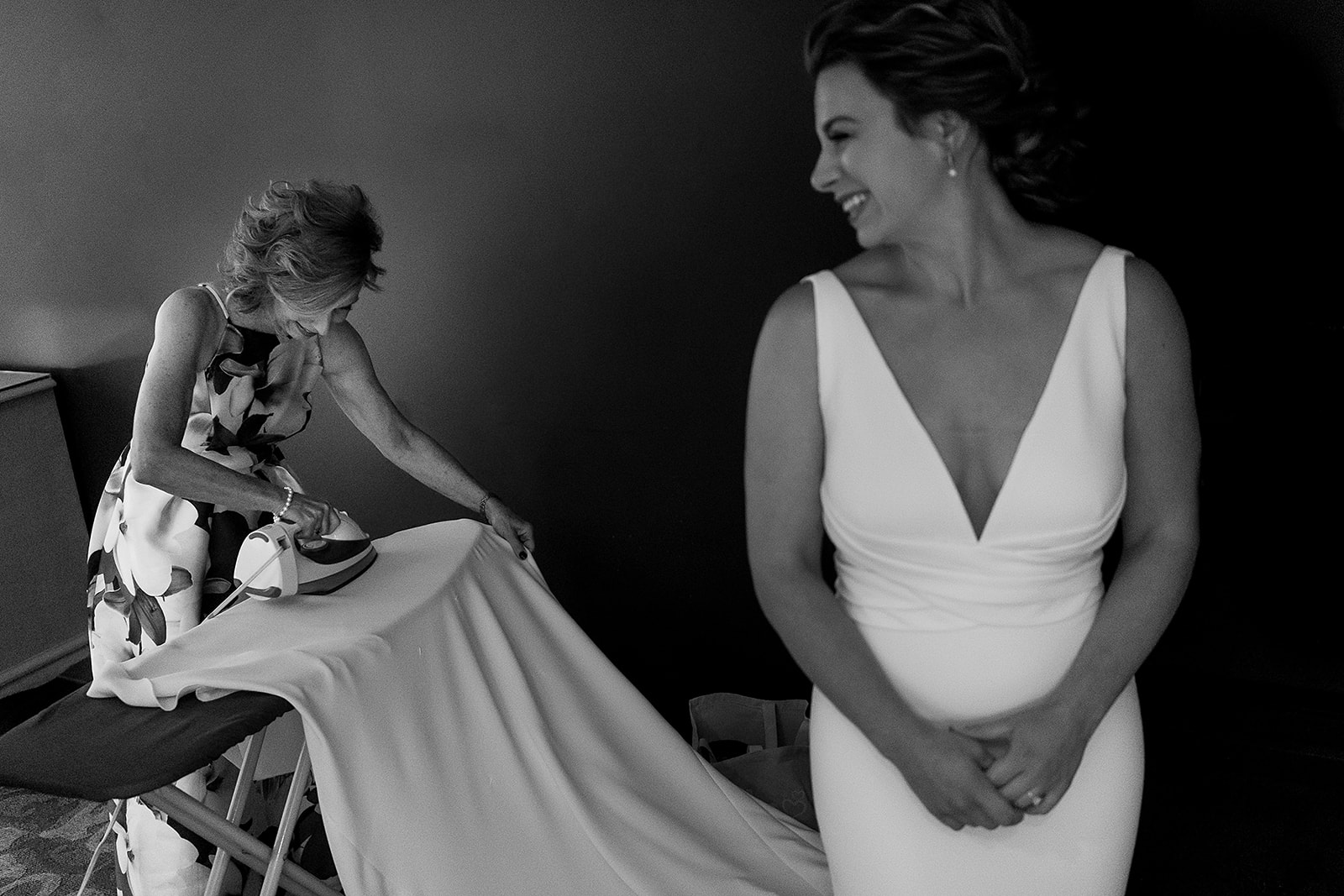 mother of the bride irons brides wedding dress while she wears it