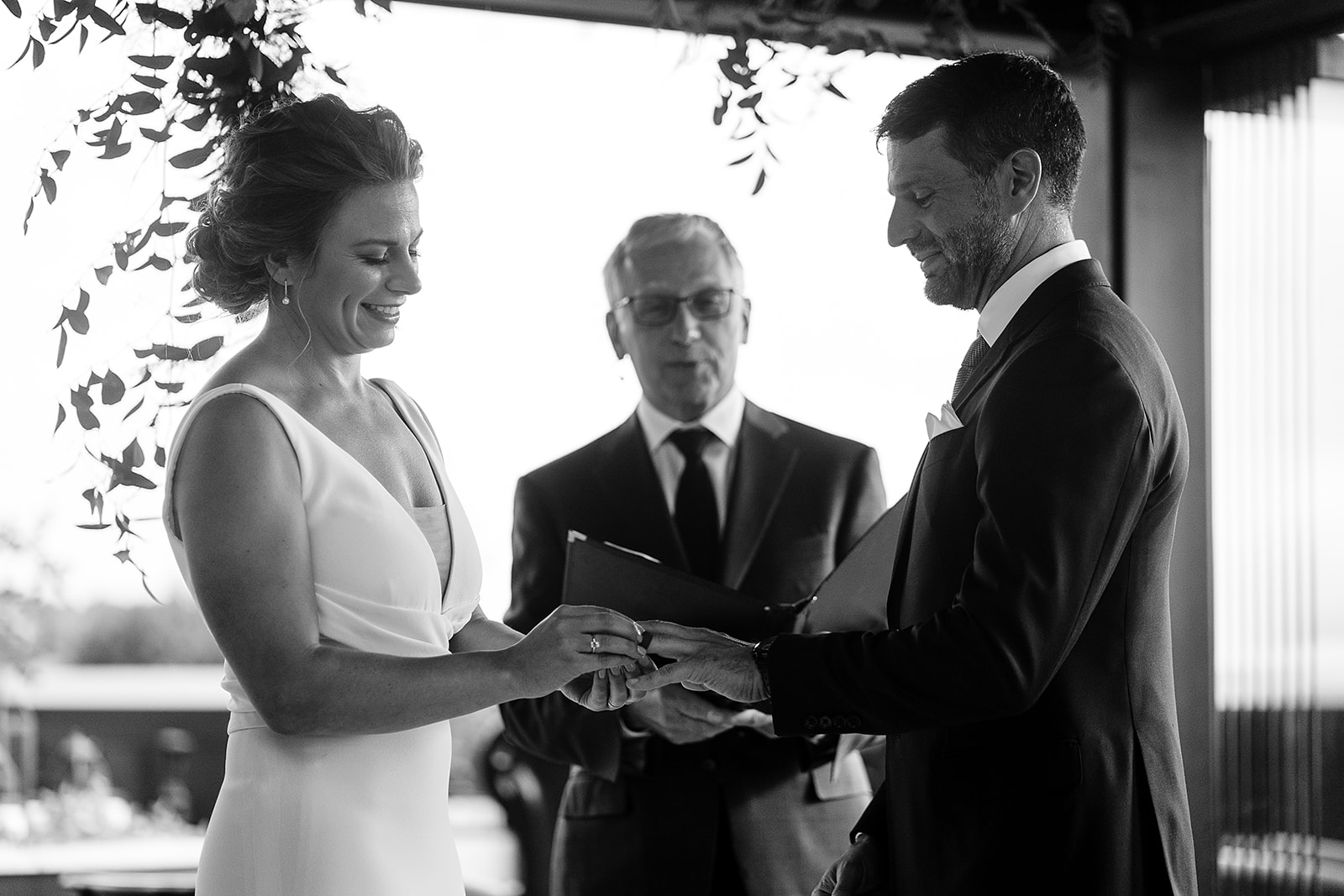 bride and groom share rings at Hotel Ballard Olympic Rooftop Pavilion Wedding