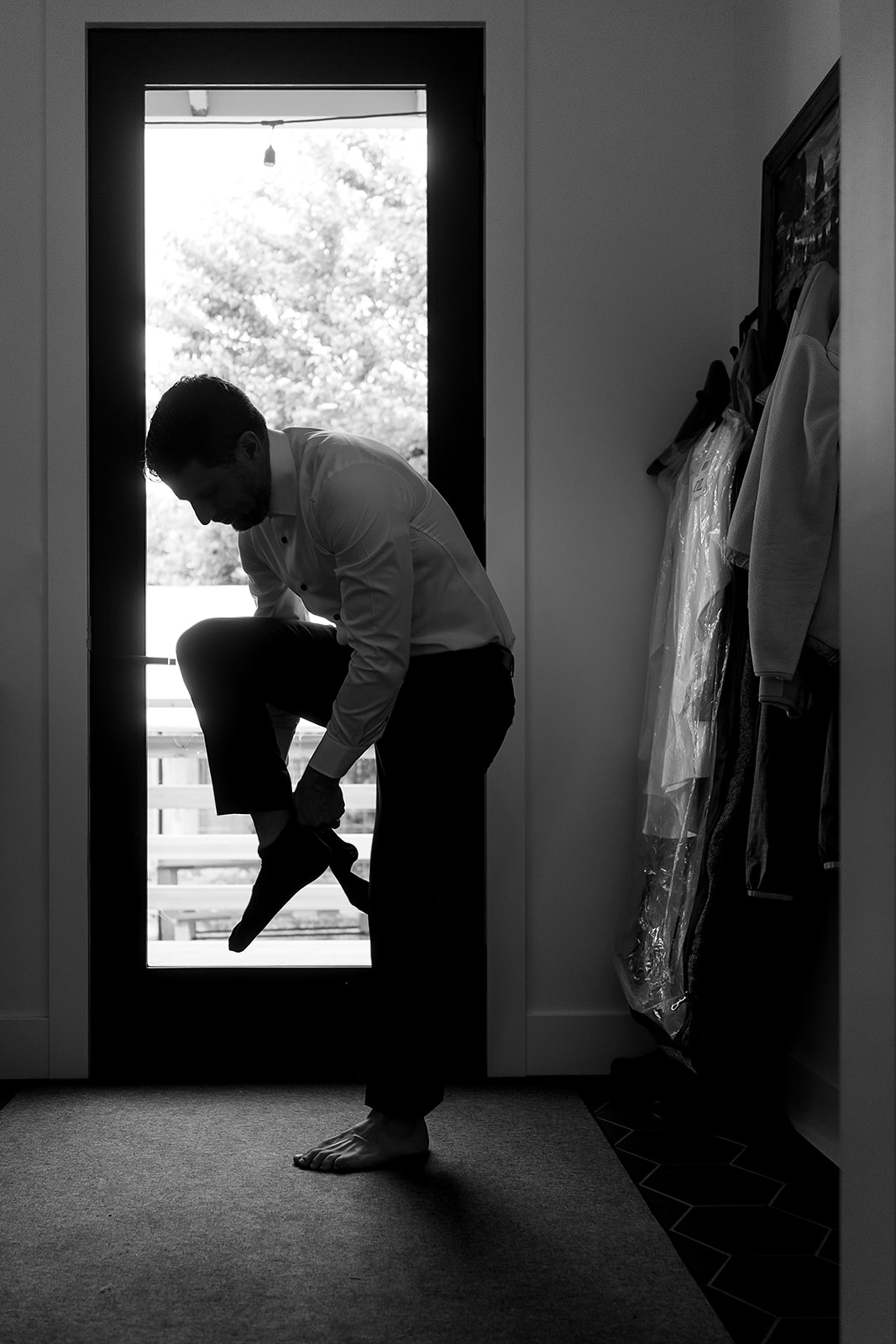 silhouette of groom putting on shoes